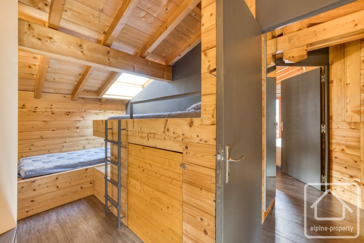 A bedroom with bunk beds and a sign that says alpine-property