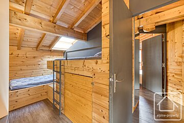 A bedroom with bunk beds and a sign that says alpine-property
