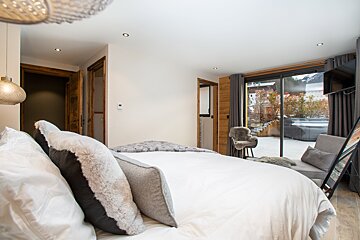 A bedroom with a large bed and a sliding glass door