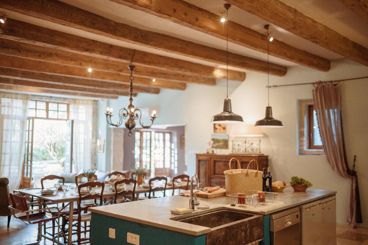 A kitchen with wooden beams and a sink