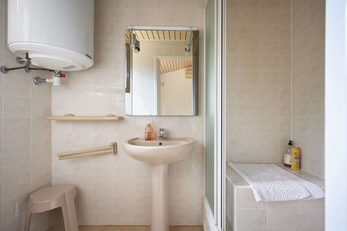 A bathroom with a sink a mirror and a water heater