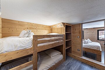 A bedroom with bunk beds and a mirror