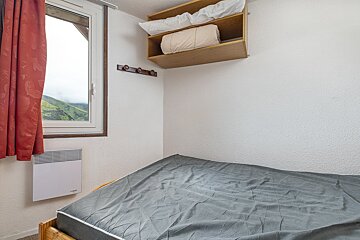 A small bedroom with a bed and a window