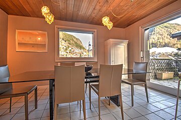 A dining room with a glass table and chairs