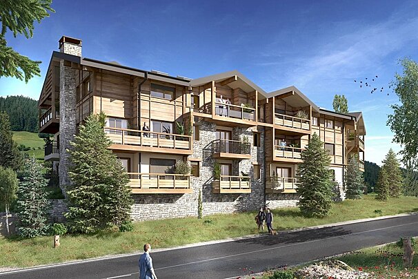 A modern, multi-story chalet-style apartment building with wood and stone facades and balconies, nestled in a mountainous landscape with pine trees and a road.