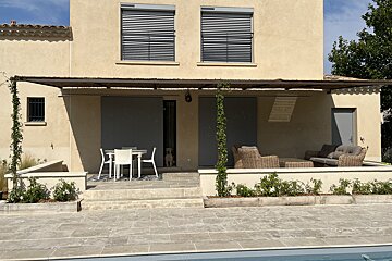 A patio area with a table and chairs in front of a house