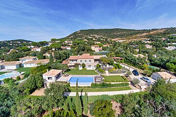 An aerial view of a house with a large swimming pool
