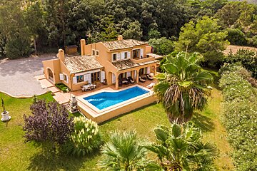 An aerial view of a house with a large swimming pool