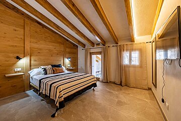 A bedroom with a large bed and a flat screen tv