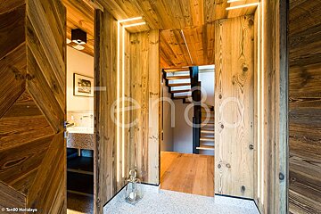 A wooden hallway with a staircase and a sign that says ten80 holidays