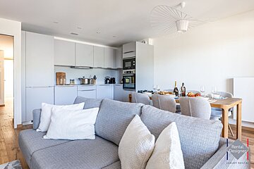 A living room with a couch and a rental designer logo