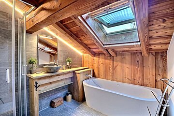 A bathroom with a skylight above the bathtub