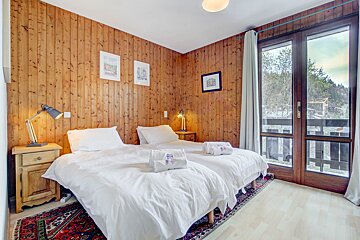 A bedroom with two twin beds and a window