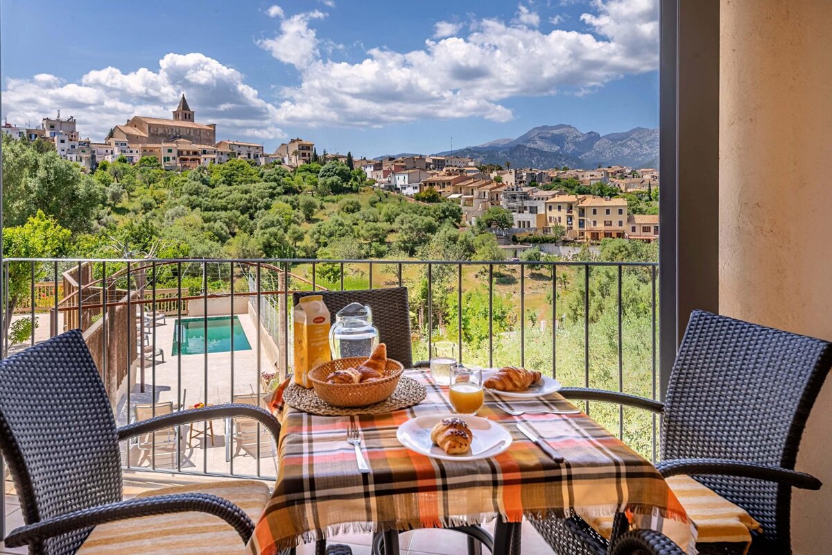 A balcony with a view of a city and mountains