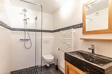 A bathroom with a toilet a sink and a mirror