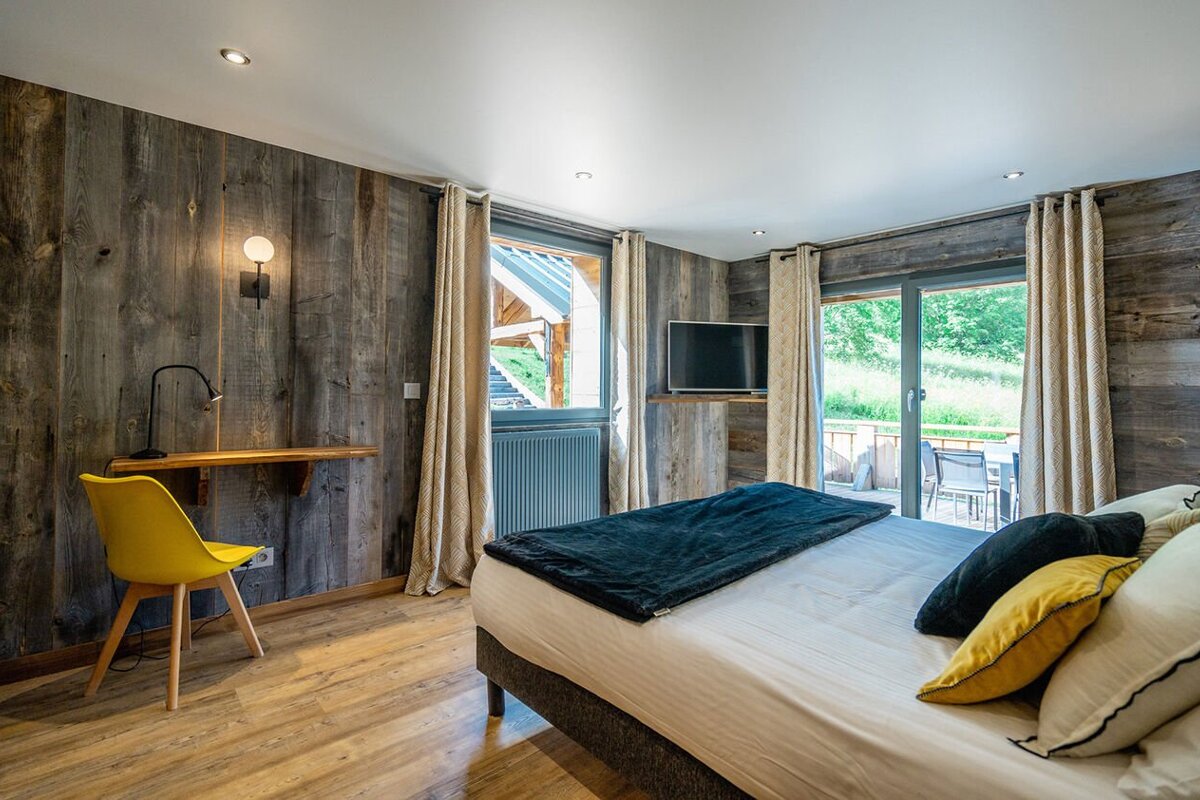 A bedroom with a large bed and a yellow chair