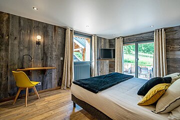 A bedroom with a large bed and a yellow chair