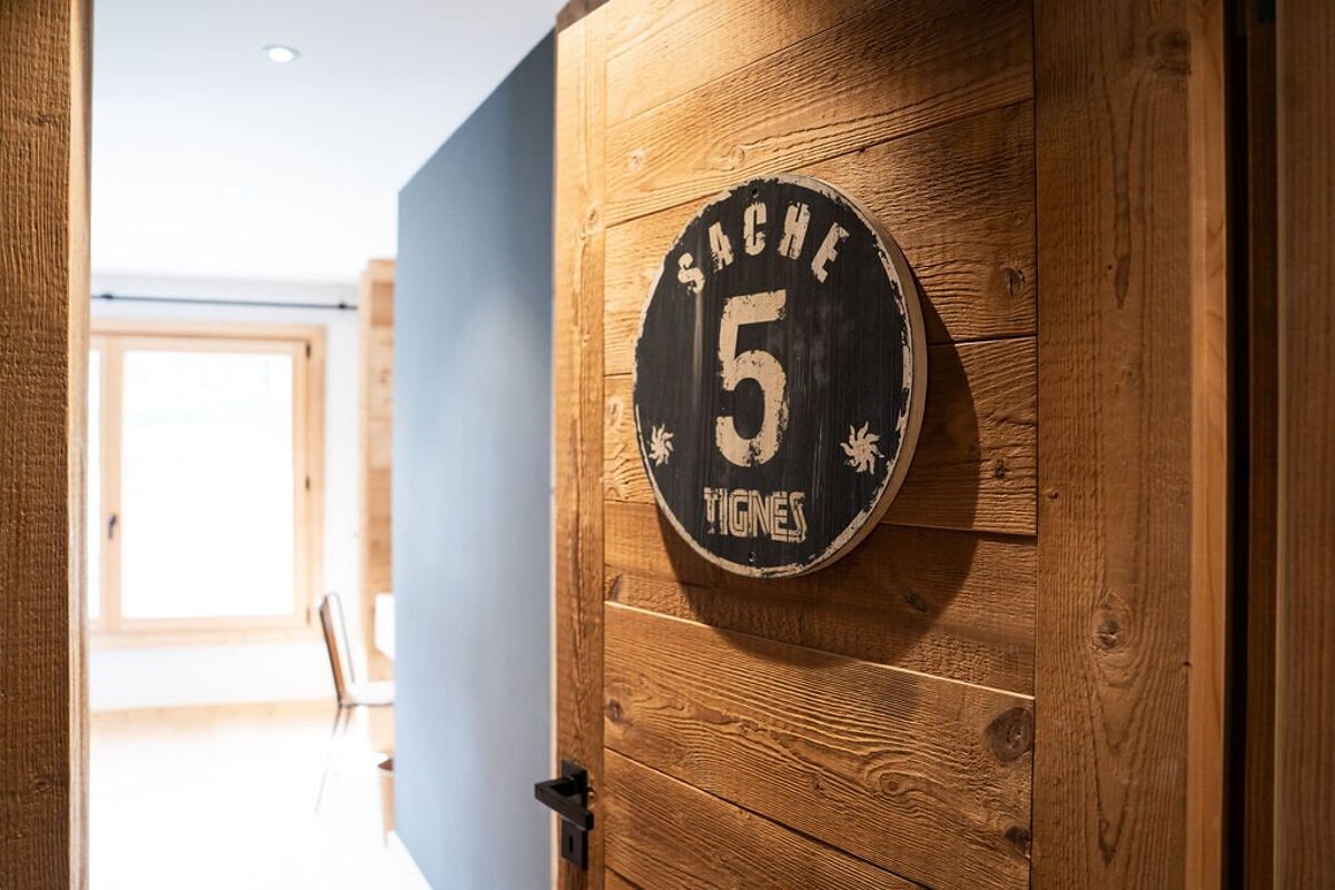 Rustic wooden door with a round black sign 