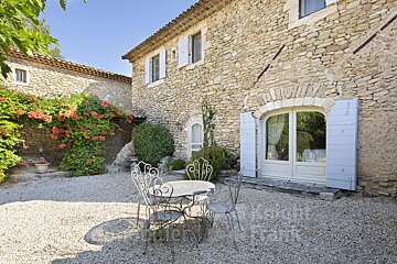A stone building with a table and chairs in front of it