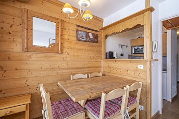 A wooden dining room with a table and chairs