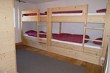 A bunk bed with a red and white checkered comforter