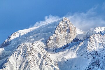A snowy mountain with a blue sky in the background