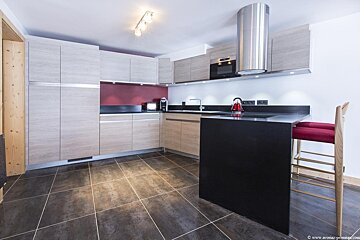 A kitchen with wooden cabinets and a black island