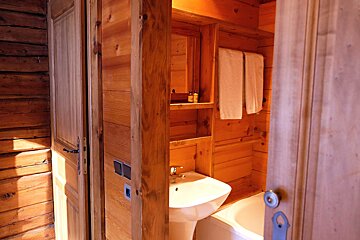 A wooden bathroom with a sink and a bathtub