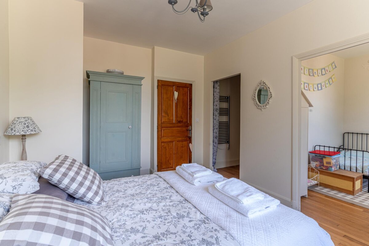 A bedroom with a bed and a wardrobe with a banner hanging from the ceiling that says happy birthday