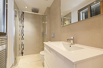 A bathroom with a toilet a sink and a walk in shower