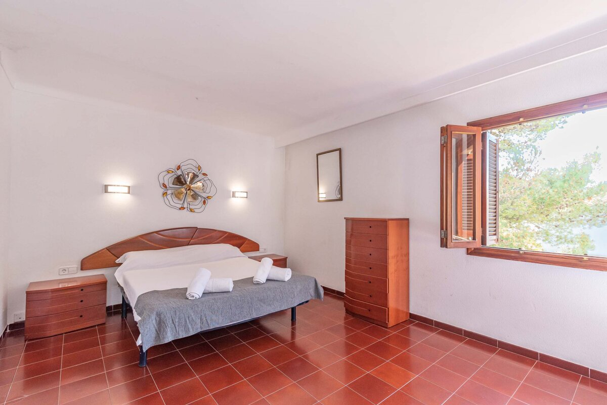 A bedroom with a bed dresser and a window