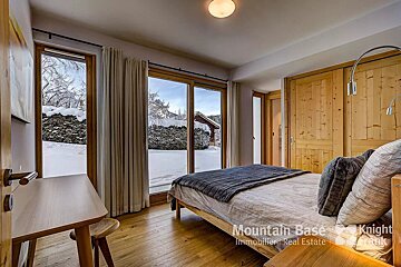 A bedroom with a bed and a window that says mountain base
