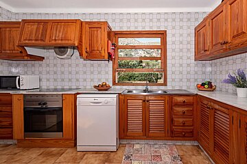 A kitchen with wooden cabinets and a white dishwasher