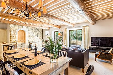 A dining room table with a bottle of wine on it