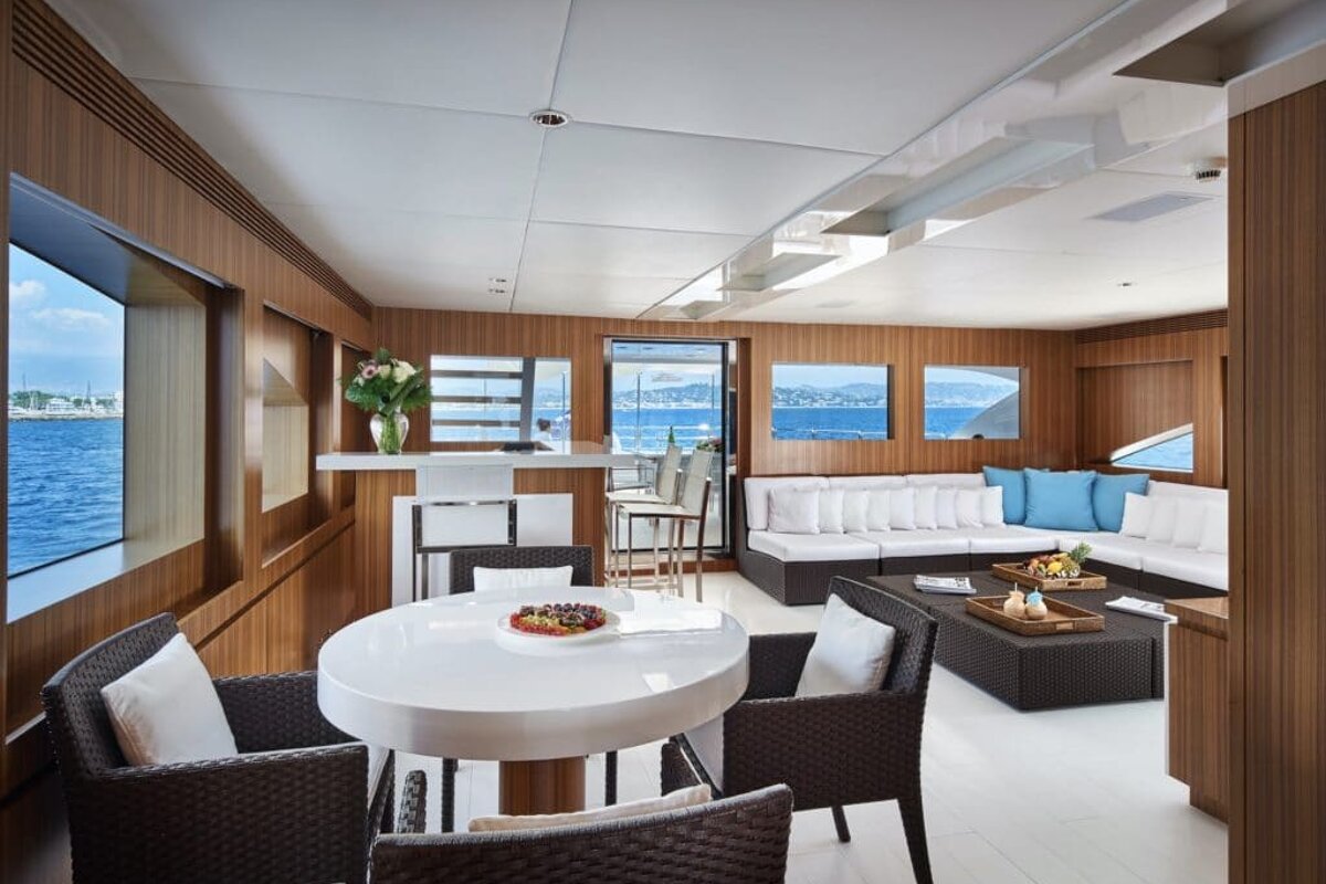 A living room with a table and chairs and a view of the ocean