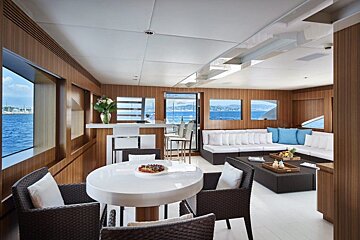 A living room with a table and chairs and a view of the ocean