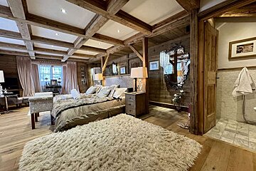 A bedroom with a large bed and a rug
