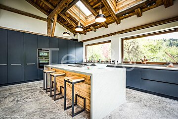 A kitchen with a large island and a skylight above it