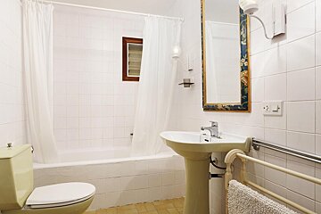 A bathroom with a toilet a sink and a mirror