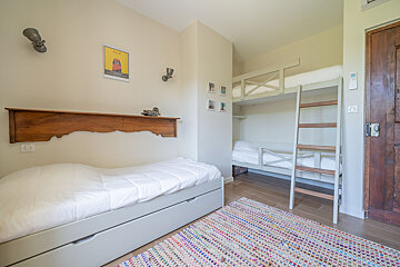 A bedroom with a bunk bed and a ladder