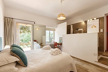 A bedroom with a large bed and a mirror