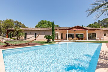 A large house with a swimming pool in front of it