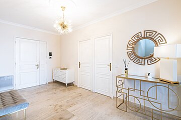 A hallway with a greek key mirror on the wall