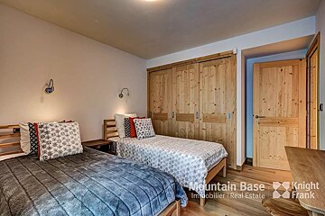 A bedroom with two beds and a sign that says mountain base