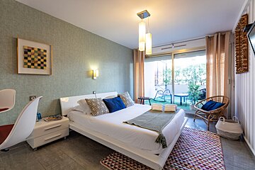 A bedroom with a sliding glass door leading to a balcony