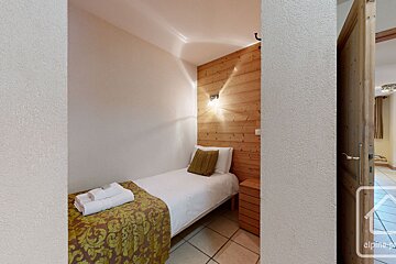 A bedroom with a single bed and a wooden wall