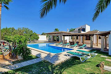 A house with a large swimming pool in front of it