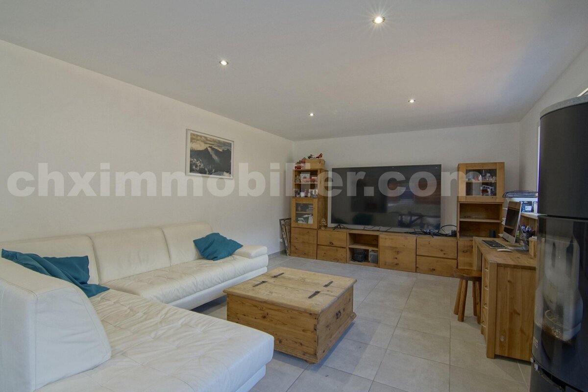 A living room with chximmobilier.com written on the wall