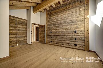 A room with a wooden wall and a knight frank logo