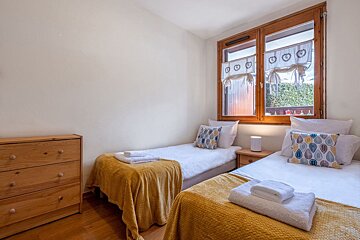 A bedroom with two twin beds and a dresser